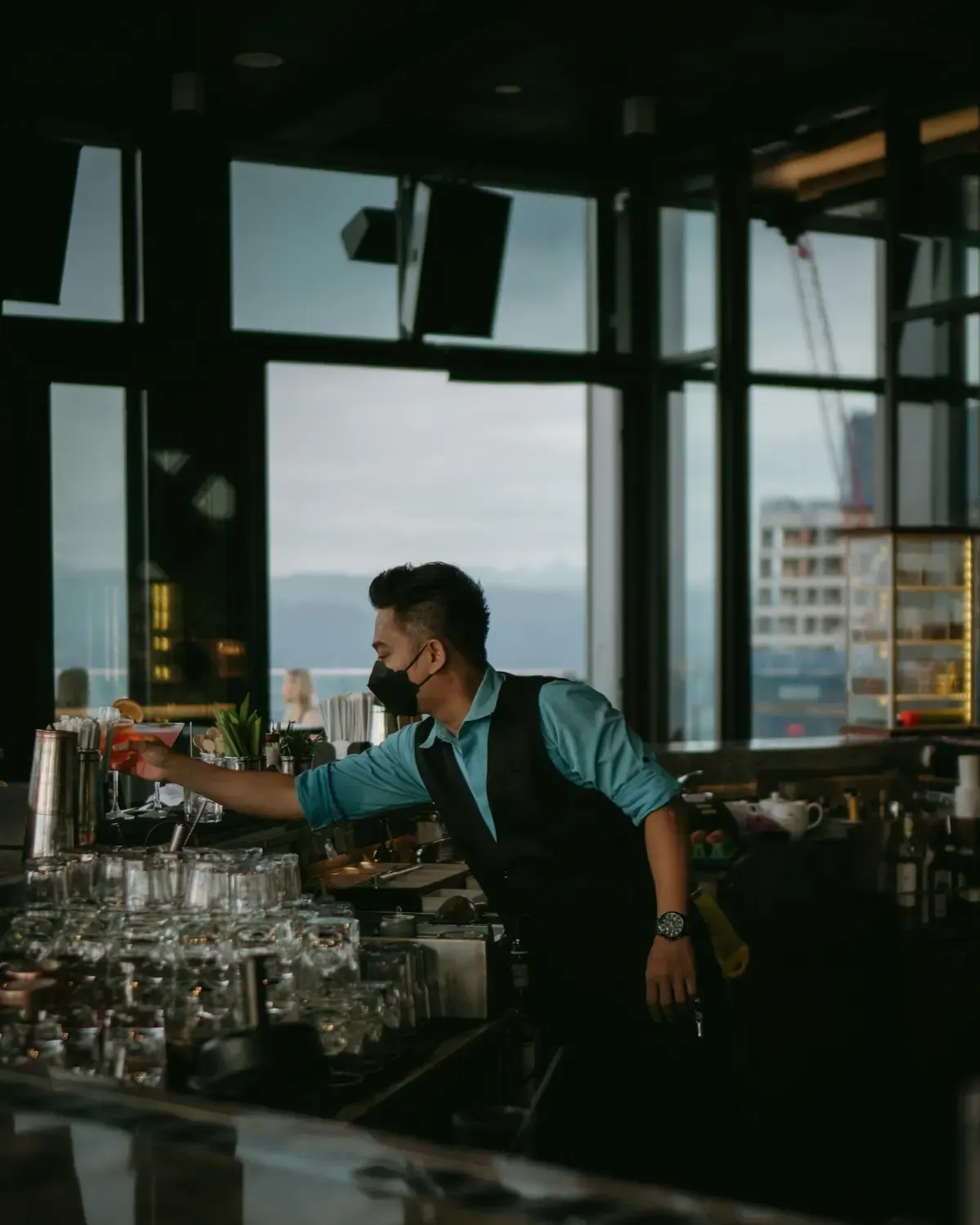 A bartender pouring a drink behind a lounge bar