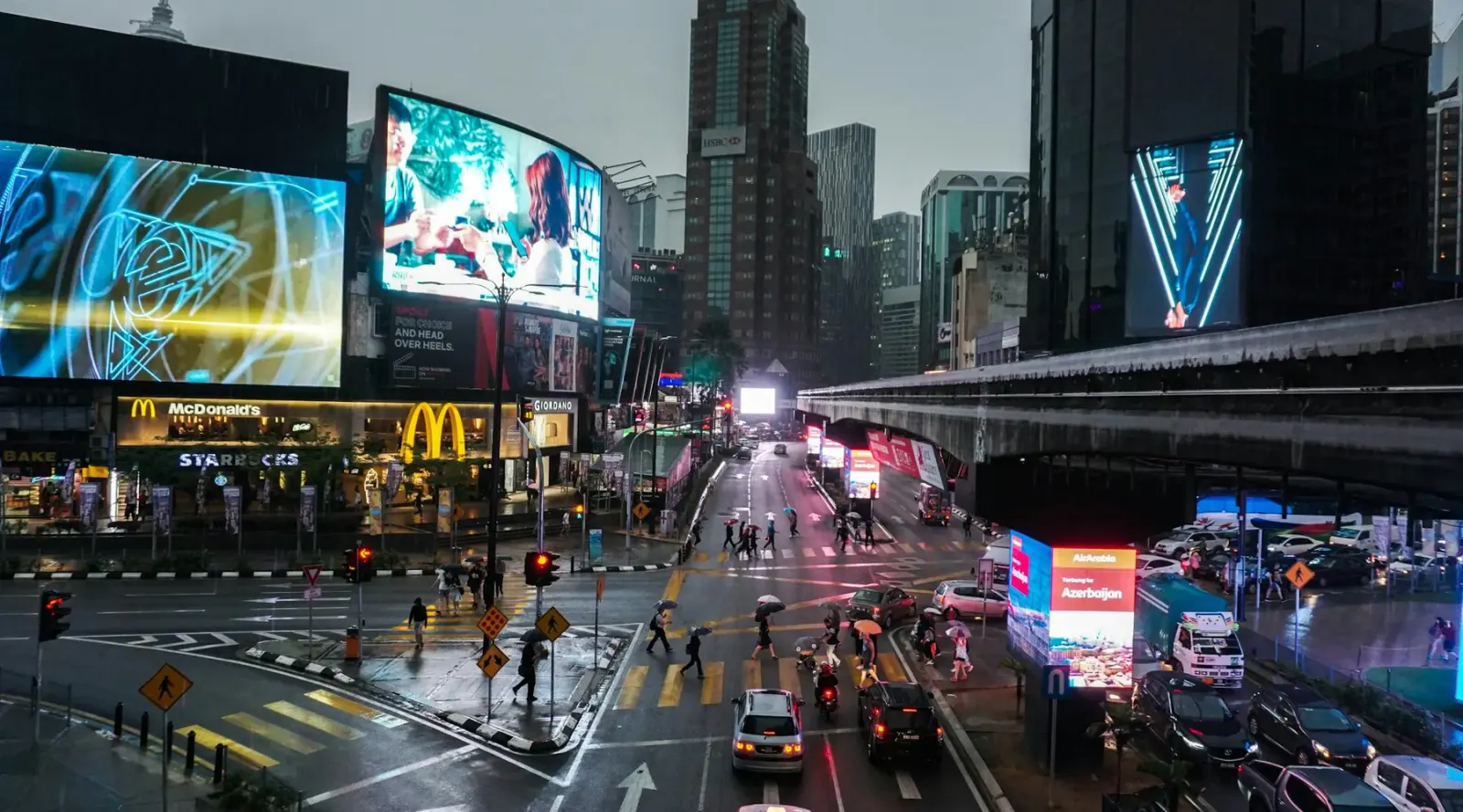 Digital billboards over a Kuala Lumpur crossing at night