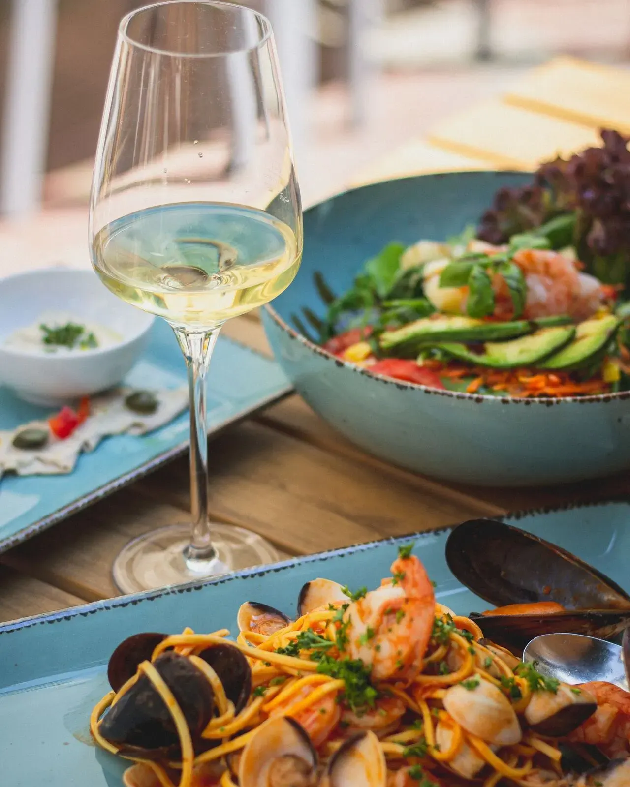 Plated dishes and white wine on a dinner table