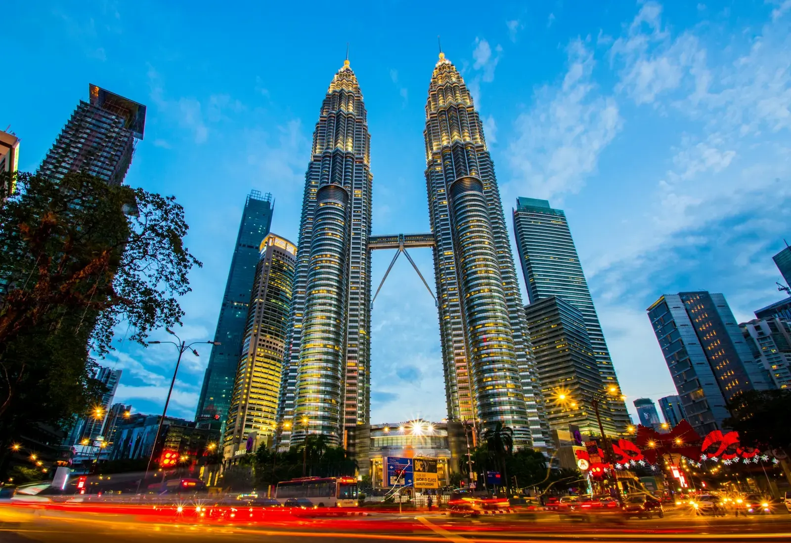 The Petronas Twin Towers seen from street level with passing traffic